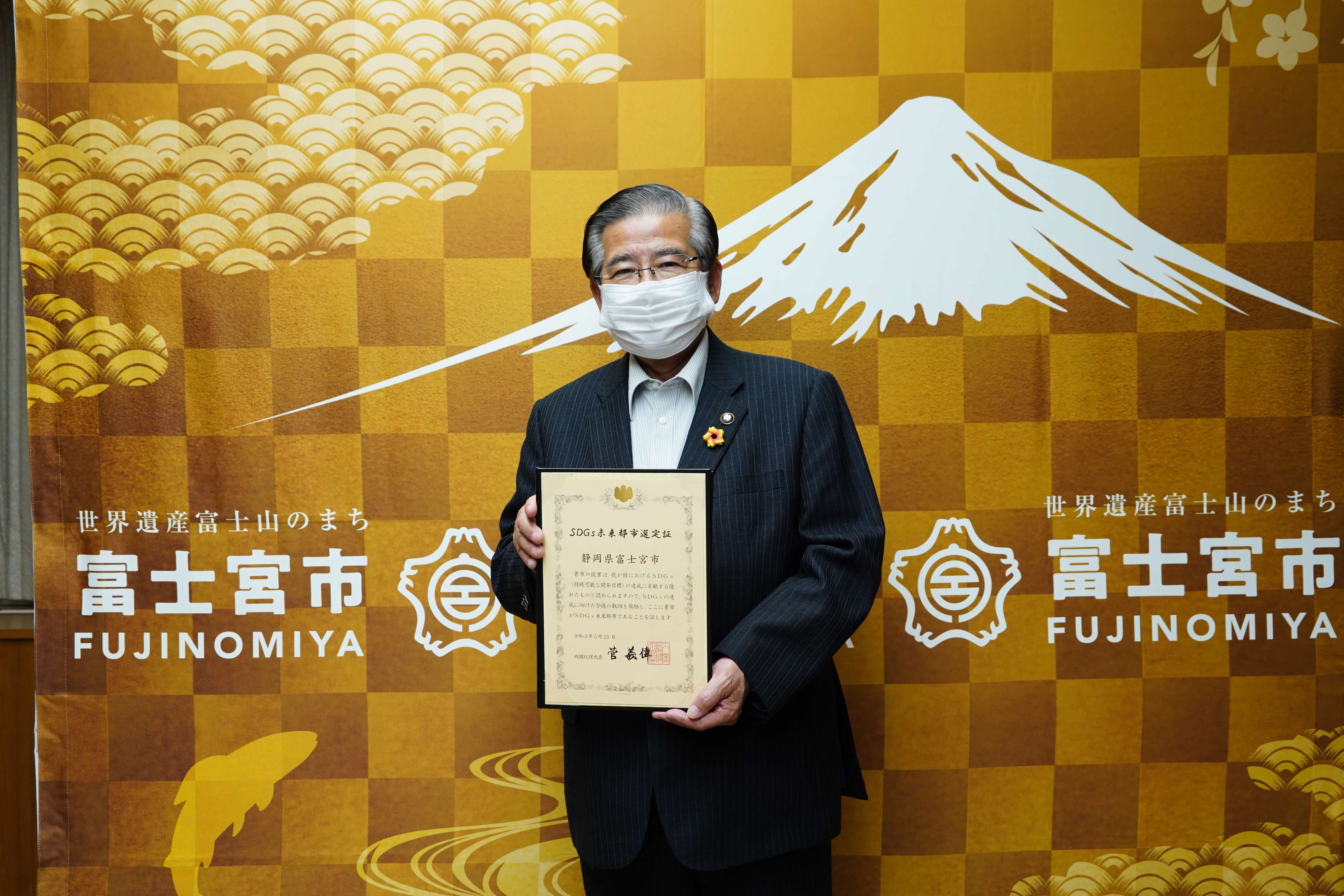 「SDGs未来都市」選定証を掲げる須藤市長