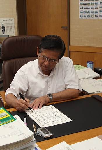 (写真)宣言書にサインする市長