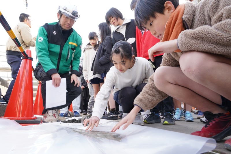 コンクリートの感触を楽しむ児童たち