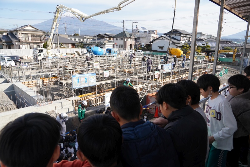 工事現場事務所から工事を見学する児童